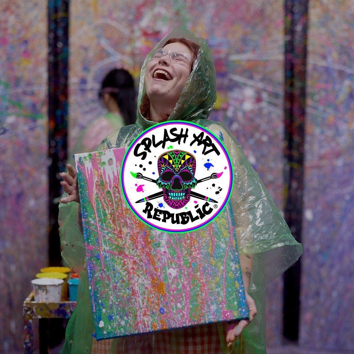 Picture of a women laughing whilst holding her art work from Splash Art Republic, displayed on top is the logo for Splash Art Republic.